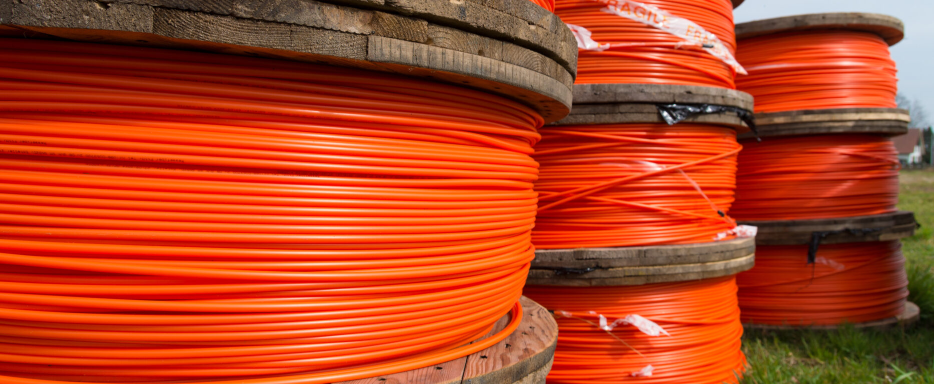 cable drums with orange fiber cable on a construction site