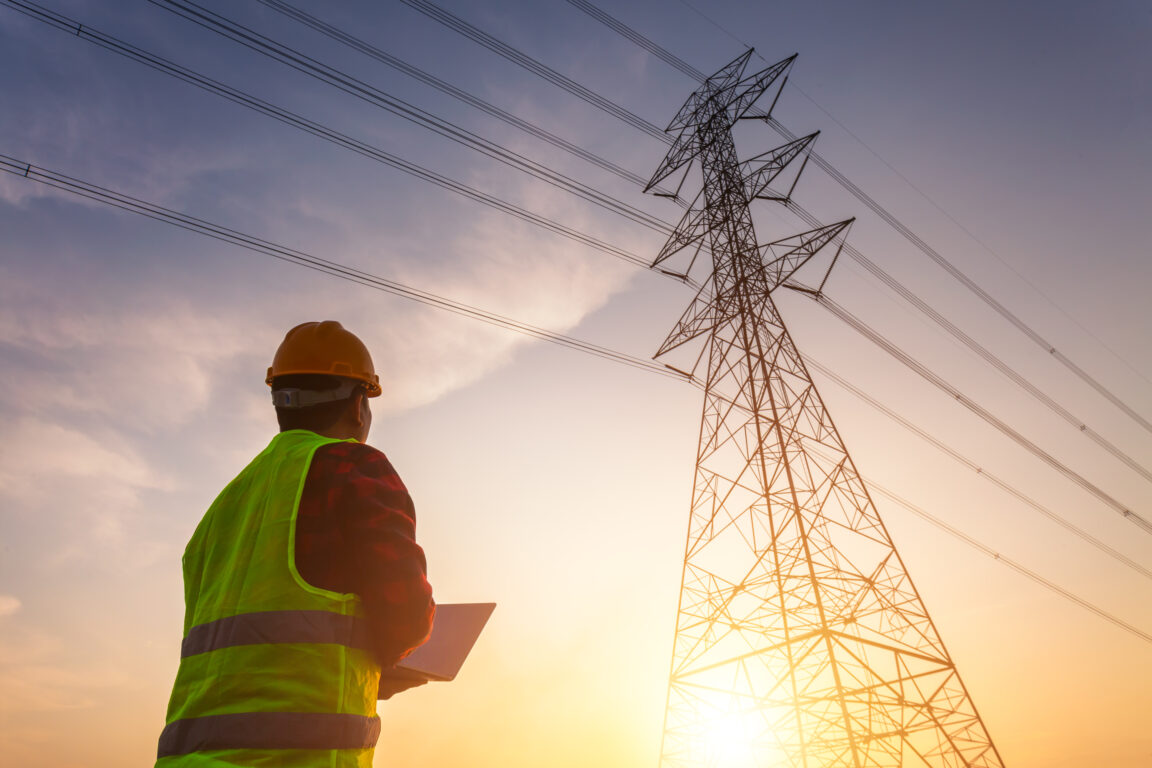 Manager Engineering in standard safety uniform working inspect the electricity high voltage pole.