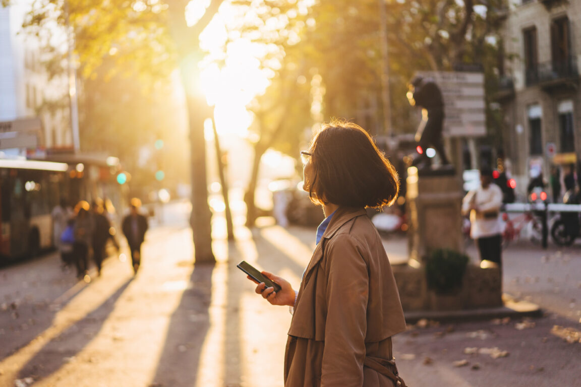 girl using smartphone on city street