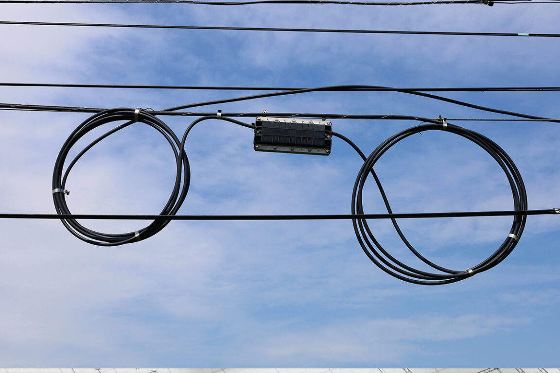 Roll of fiber optic cable hanging from a pole.